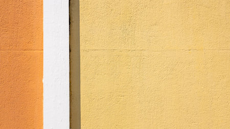 Pastel yellow cement wall of house building, White cement wall with yellow orange contrast with sunlight and shadow on the surface of background, Exterior architecture design concept of house.の写真素材