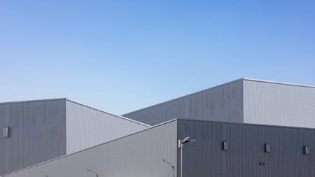 Factory industry, Warehouse Construction in Geometric Modern Design, Modern Industrial Warehouse Exterior on a Sunny Day, Backdrop Wall Metal Corrugated Steel Surface Pattern.の写真素材