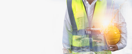 Double exposure worker wearing safety uniform and helmet hard hat work with show project construction building background, Civil engineer architect standing holding a safety helmet on white backgroundの写真素材