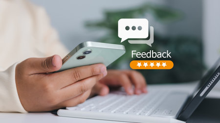 Customer satisfaction, online review, and business service evaluation. Close-up of person holding smartphone with feedback and five-star rating icon.の写真素材
