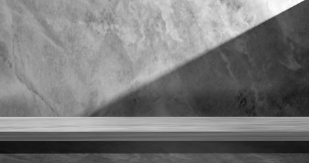 Minimalist black and white 3D render with sleek stone product display table, textured marble wall, and dramatic diagonal shadow, perfect for product mockups, branding, and elegant presentations.の写真素材