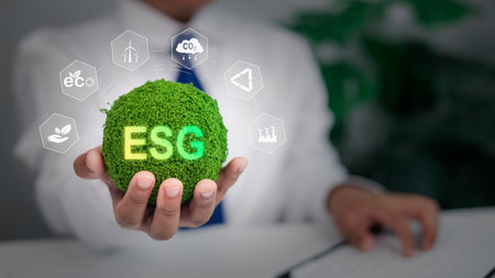 Professional holding glowing green globe with ESG text and sustainability icons, Corporate social...