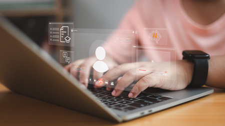 Modern artificial intelligence and online learning concept. Person typing on laptop with virtual AI, education, and communication icons representing digital innovation and e-learning.の写真素材