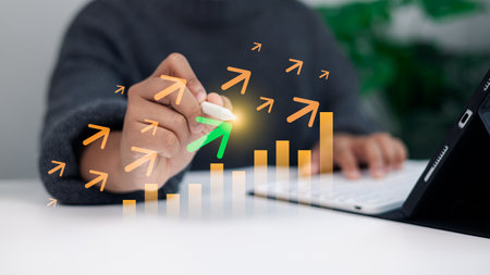 A businessperson drawing upward arrows and a rising bar chart symbolizing business growth, success, and digital marketing strategy in modern technology concept.の写真素材