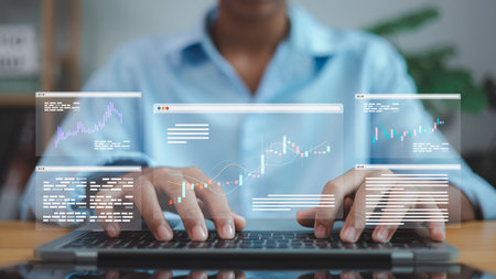 Businessman using laptop with digital financial charts and data analytics interface. Concept of fintech, stock trading, business growth, and modern data technology.の写真素材