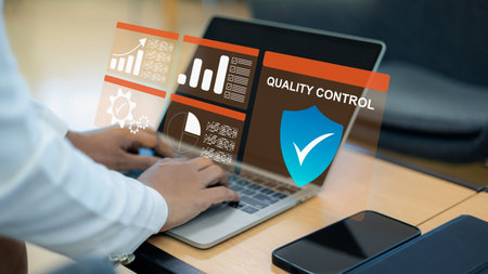 Close up of person using laptop with virtual quality control dashboard, shield icon and data charts....