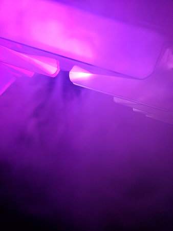 Background abstract purple with neon glow, lights, glowing lines and smoke. Pink blue, ultraviolet spectrum, laser show, fogの写真素材