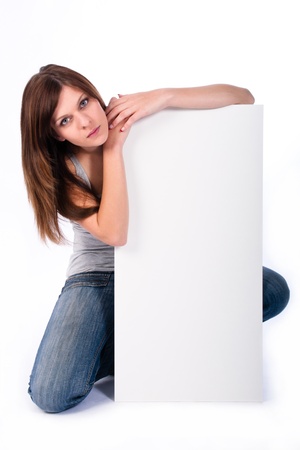 beautiful young woman kneeling behind signの写真素材