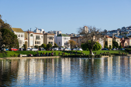 People walking on the Palace of Fine Arts pond shoreline on a sunny dayのeditorial素材