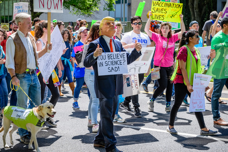 April 14, 2018 Sacramento / CA / USA - Participants to the March for Science and the Tax March walk on the Capitol Mall; a person impersonating Trump walks in the first rowのeditorial素材