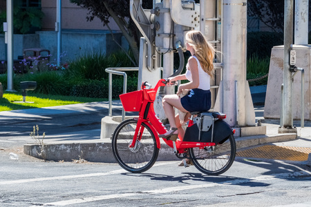 September 23, 2018 Sacramento / CA / USA - Girl riding a Jump electric bike; JUMP Bikes is a dockless electric bicycle sharing system acquired by UBER; it operates in US and Germanyのeditorial素材