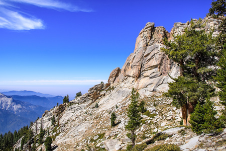 High altitude landscape in Sequoia National Park, Sierra Nevada mountains; blue sky and smoke from wildfires covering the valley visible in the background; Californiaの写真素材