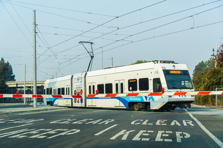 November 10, 2018 Mountain View / CA / USA - Waiting at a barrier for a VTA Train to pass in south San Francisco bay; smoke from wildfires visible in the airのeditorial素材