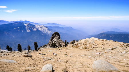 Aerial views of the hiking trail and the valley beyond as seen from Alta Peak in Sequoia National Park, Sierra Nevada mountains, California; smoke from wildfires visible in the backgroundの写真素材