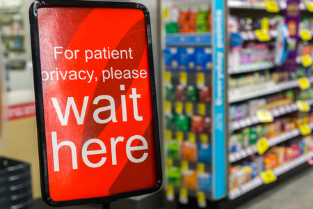 "For patient privacy please wait here" sign posted in a pharmacyの写真素材