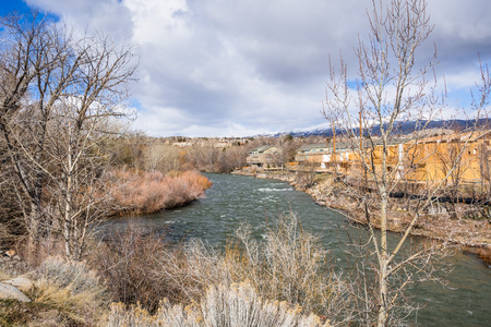 Truckee River flowing through a residential neighborhood in Reno, Nevada; snow covered mountains in the backgroundの写真素材