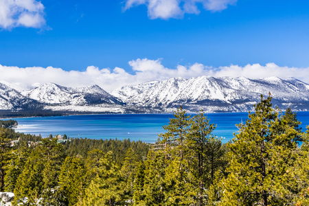 View towards Lake Tahoe on a sunny clear day; the snow covered Sierra mountains in the background; evergreen forests in the foregroundの写真素材