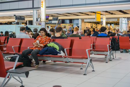 September 10, 2017 London/UK - People sitting on the chairs in one of the waiting areas at Heathrow airportのeditorial素材