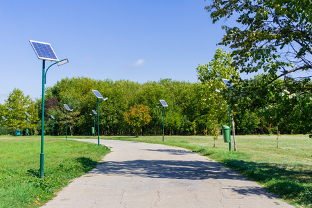 Park alley illuminated by solar powered street lights in Tineretului Park, Bucharest, Romaniaの写真素材