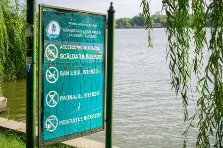 September 19, 2017 Bucharest/Romania - No swimming, skating, fishing or sledding on the lake surface posted warnings on a panel on the shore of Herastrau lake, in the north part of the cityのeditorial素材