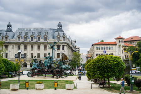 September 22, 2017 Bucharest/Romania - "A Carriage with Clowns" sculpture by I Bolborea in front of the National Bucharest Theater (TNB); the Bucharest University in the background, Romaniaのeditorial素材