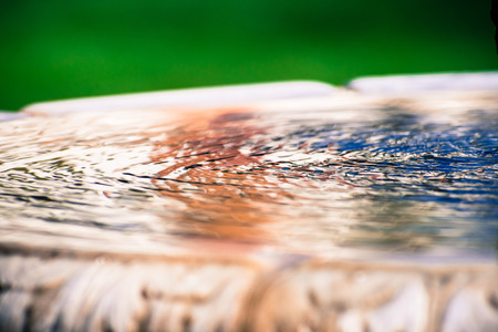 Ripples in a water fountain; colorful backgroundの写真素材