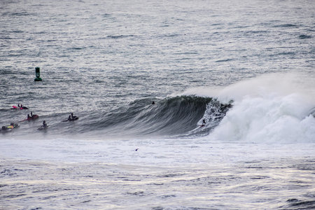 Surfers riding huge waves on the west coast, close to Pillar Point and Mavericks Beach, Half Moon...