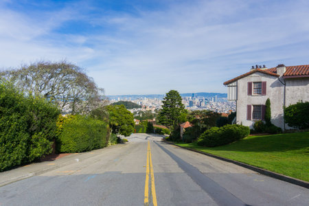 Two way street in the residential area of San Francisco; downtown views in the background,...