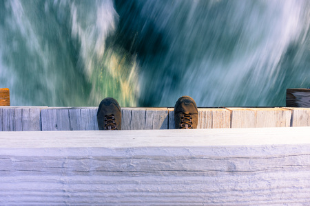 Looking down from a bridge at a fast running riverの写真素材