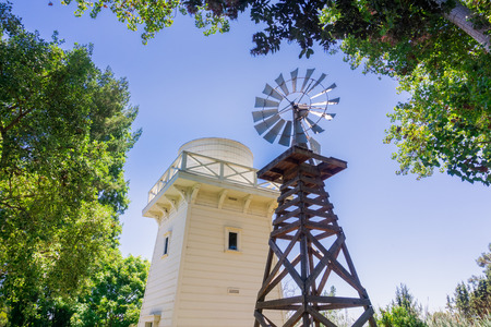 Old wind turbine and wooden water tower, Rengstorff house, Shoreline Lake and Park, Mountain View, Californiaの写真素材