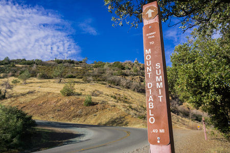 Posted sign on the hiking trail to Mt Diablo peak (visible in the background) at a place where the trail intersects the road, Mt Diablo State Park, Contra Costa county, San Francisco bay, Californiaの写真素材
