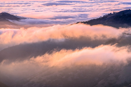 Clouds bathed in the sunset light covering rolling hills, south San Francisco bay area, California
