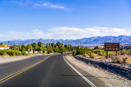Highway through Death Valley National Park, Furnace Creek 190 feet below sea level sign on the side...