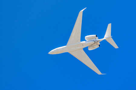 Looking up at a low flying airplane; blue sky backgroundの写真素材