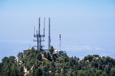 Radio antennas on the mountains of Angeles National Forest, haze covering the valley in the background; Los Angeles county, Californiaの写真素材