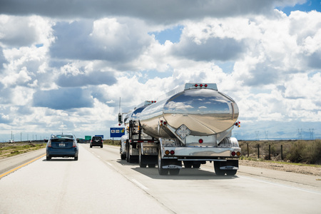 March 15 2018 Lost Hills / CA / USA - Tanker truck driving on interstate I5, the road being reflected in its shiny cistern;のeditorial素材