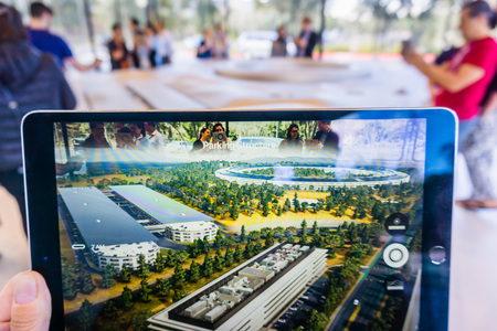 March 8, 2018 Cupertino / CA / USA - People at the Apple Park Visitor Center in Silicon Valley explore the new Apple Offices using a scaled-down replica of the campus and a virtual reality programのeditorial素材