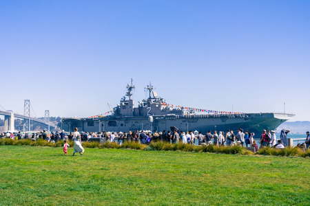October 7, 2017 San Francisco/CA/USA - Ship anchored at one of the city piers during fleet week; people standing in line for a free tour on a sunny dayのeditorial素材