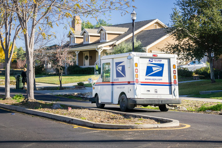 December 12, 2017 Livermore / CA / USA - USPS vehicle driving through a residential neighborhood on a sunny dayのeditorial素材
