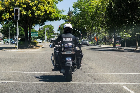 August 2, 2018 Mountain View / CA / USA - A motorcycle police officer on patrol on the streets of south San Francisco bay area; back viewのeditorial素材