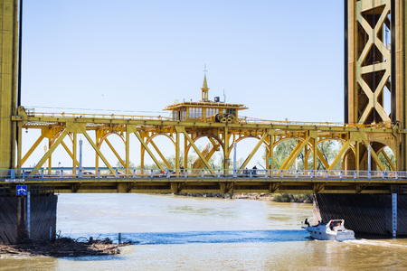 April 14, 2018 Sacramento / CA / USA - People sightseeing on the Tower Bridge; boat passing underneath itのeditorial素材