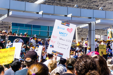 June 30, 2018 San Jose / CA / USA - "Build Unity, Not Walls, Not Detention Centers" sign raised at the "Families belong together" rally held in front of the City Hall in downtown San Joseのeditorial素材