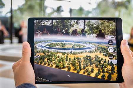 April 29, 2018 Cupertino / CA / USA - People at the Apple Park Visitor Center in Silicon Valley explore the new Apple Offices using a scaled-down replica of the campus and a virtual reality programのeditorial素材