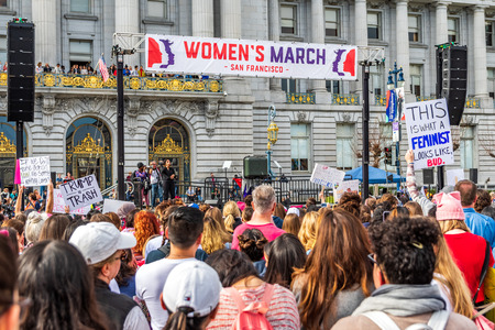 January 19, 2019 San Francisco / CA / USA - Participants to the Women's March event hold signs with various messages; the rally stage and the City Hall building visible in the backgroundのeditorial素材