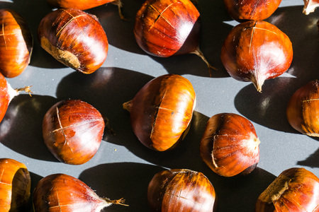Chestnuts about to be roasted on a metal trayの写真素材