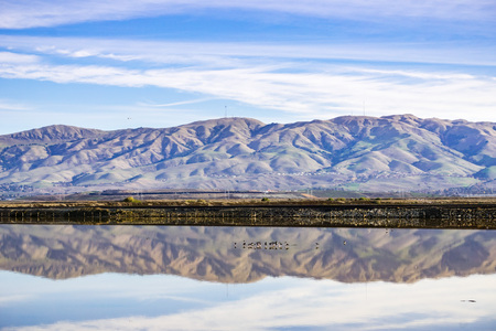 Train tracks crossing south San Francisco bay, Mission Peak and Monument Peak on the background, Alviso marsh, San Jose, Californiaの写真素材