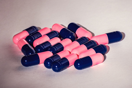 Close up of pink and blue Amoxicillin antibiotics capsule pills. Concept for Antimicrobial drug resistance; pharmaceutical industry; Global healthcareの写真素材