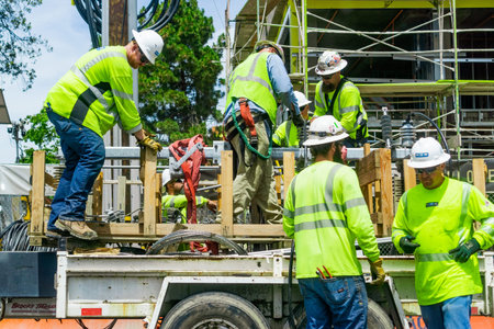June 24, 2019 Mountain View / CA / USA - Team of construction workers wearing bright yellow vests...