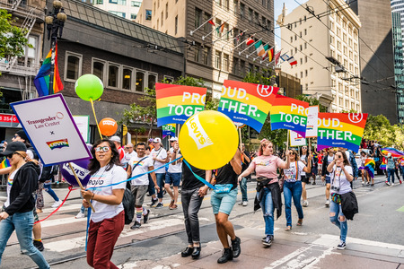 June 30, 2019 San Francisco / CA / USA - Unidentified participants, carrying Proud Together signs, part of Levi's caravan, march at the SF Pride Parade on Market Street in downtown San Franciscoのeditorial素材