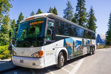 June 27, 2019 Yosemite National Park / CA / USA - The Yosemite Glacier Point guided tour bus, operated by Aramark, available from late May to early November; Half Dome visible in the backgroundのeditorial素材